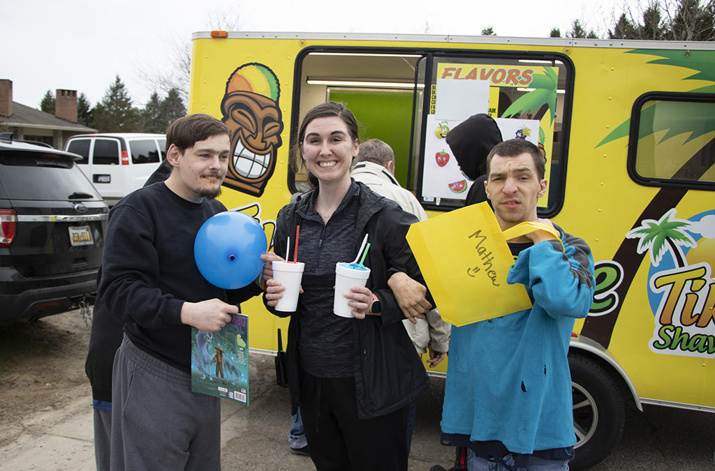 two men with disabilities get slushies with a female staff member