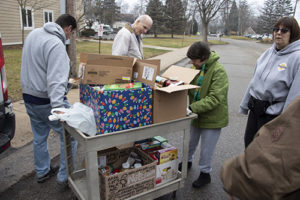 St. Louis Center staff and residents moving a cart of canned goods.