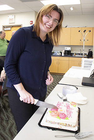 A young woman cutting a cake