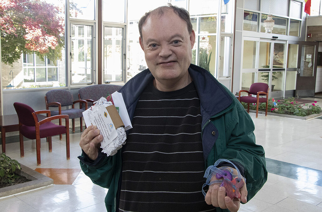 Man with developmental disabilities holding handicrafts