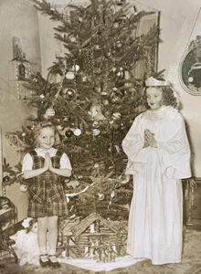  1940s vintage photo of two girls standing by a Christmas Tree