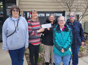 Women with disabilities presenting a check to the head of Faith in Action