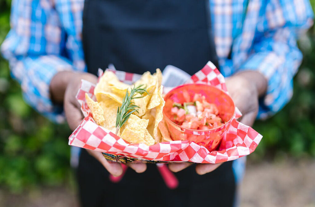 person holding chips and salsa